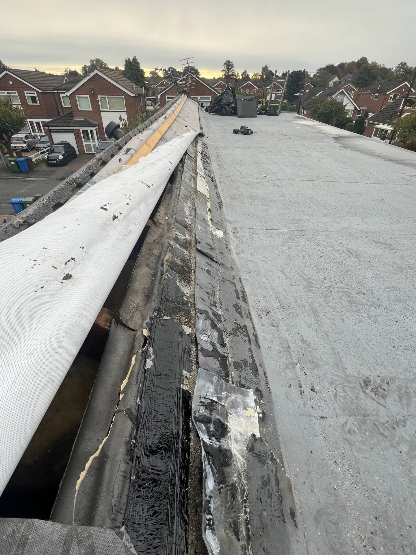 Old failed felt flat roof with damaged edge before replacement