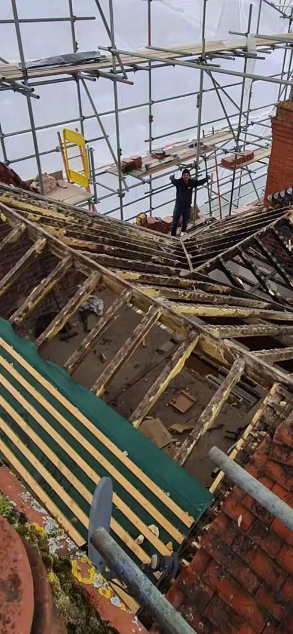 Old roof stripped back to exposed rafters with scaffolding