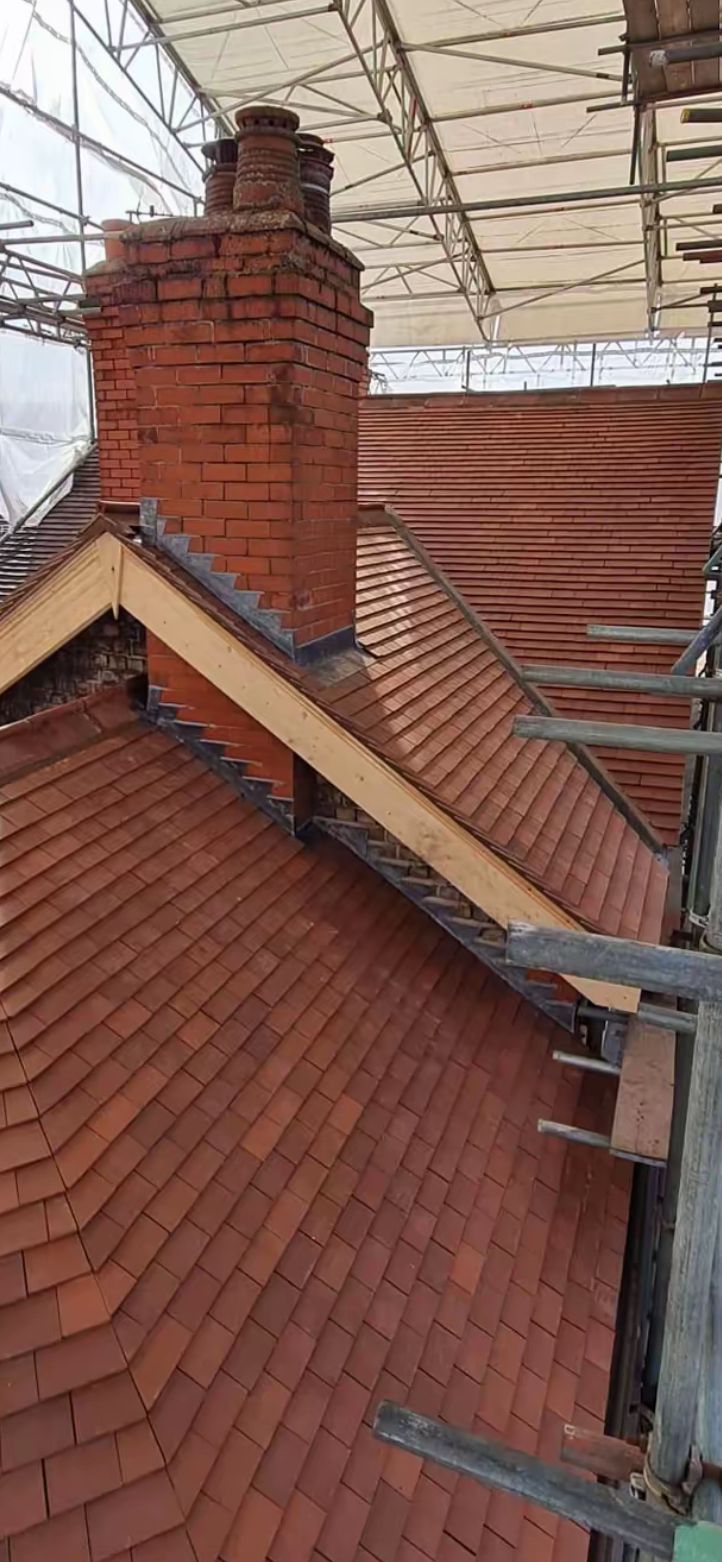 Finished red clay tile roof with restored brick chimney